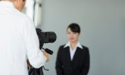 証明写真を撮影するスーツ姿の女性