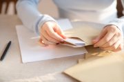封筒に書類を入れている手元