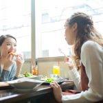 カフェで食事しながら談笑する二人