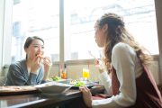 カフェで食事しながら談笑する二人