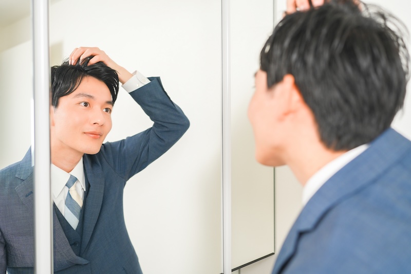 鏡の前で髪を整える様子