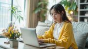 ノートパソコンを開いてメールの内容を考えている学生