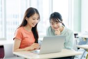 パソコンを見ながら話す学生たち