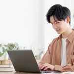 部屋でパソコンに向かう男性