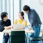 パソコンを見ながら話す学生たち