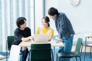 パソコンを見ながら話す学生たち
