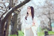 桜並木の河川敷を歩く学生のイメージ