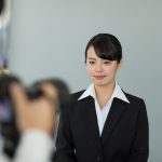 証明写真を撮影するスーツの女性