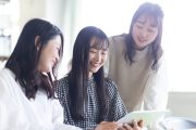 タブレットを見ながら話し合いをする学生たち