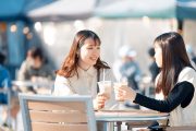 テラス席でコーヒーを飲む2人の学生