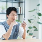 リビングでスマホを使う学生