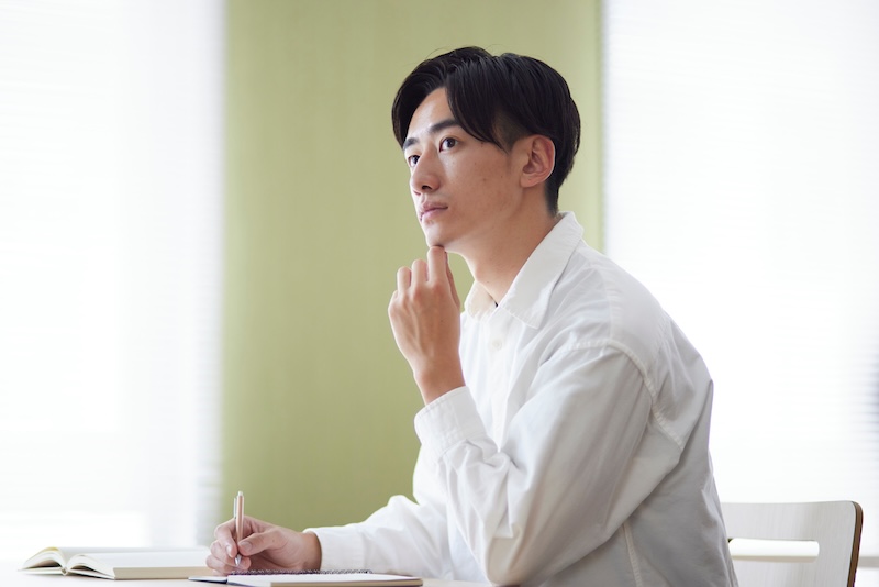 大学の図書室で勉強をする学生